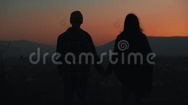 恋爱中的年轻夫妇在山上欣赏日落的<strong>剪影</strong>。 假期，旅行，浪漫，<strong>求婚</strong>